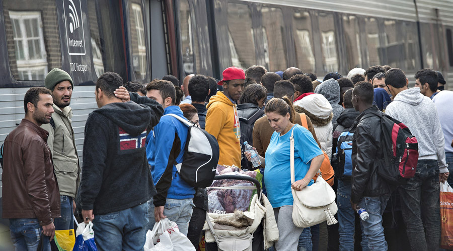 Migrants mainly from Syria prepare to board a train headed for Sweden at Padborg station in southern Denmark