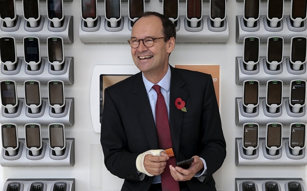 Sainsbury's Chief Executive Mike Coupe poses near a bank of Smart Shop handsets at a Sainsbury's store in northwest London Britain