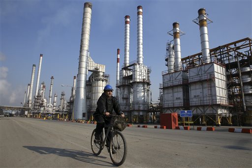 Iranian oil worker rides his bicycle at the Tehran's oil refinery south of the capital Tehran Iran. Oil prices that slumped steeply earlier this year may take another hit once a historic deal between the W
