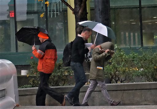 Pedestrians cover up from heavy El Nino rains in downtown Los Angeles Wednesday Jan. 6 2016. The system Wednesday will pack colder temperatures stronger winds and heavier rainfall than the two previous storms that have battered the state since the