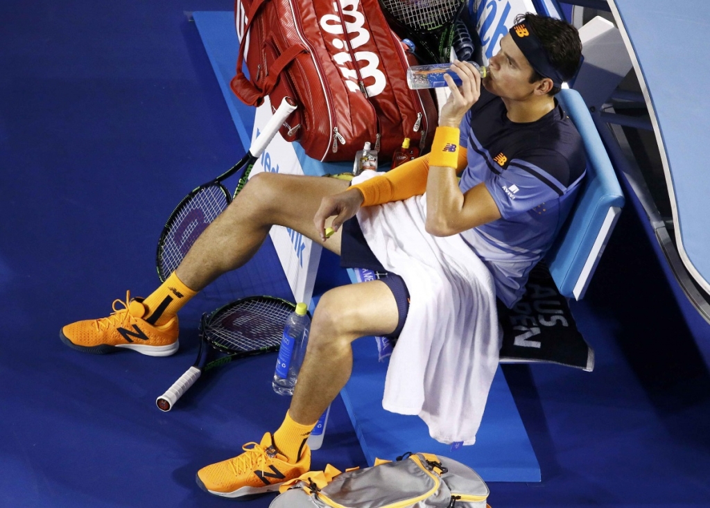 Canada's Milos Raonic drinks with his broken racquet on the floor beside him after smashing it on the court during his semi-final match against Britain's Andy Murray at the Australian Open tennis tournament at Melbourne Park Australia