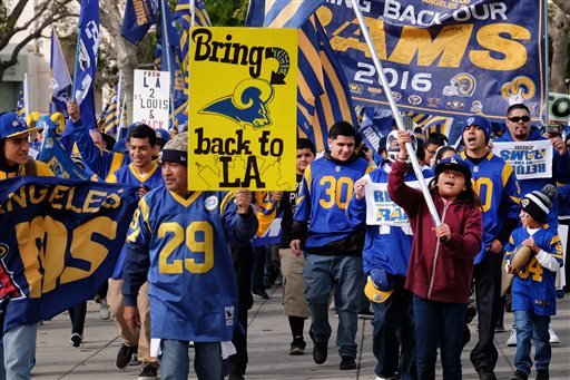 Rams football fans hold banners wave signs and chant while marching around the historic Los Angeles Memorial Coliseum. Saturday Jan. 9 2016 in Los Angeles. Boisterous Los Angeles Rams fans gathered Saturday to herald the NFL football team's possibly