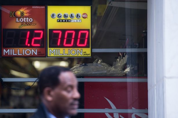 A sign in the window of a liquor store shows the Powerball lottery jackpot at $700 million