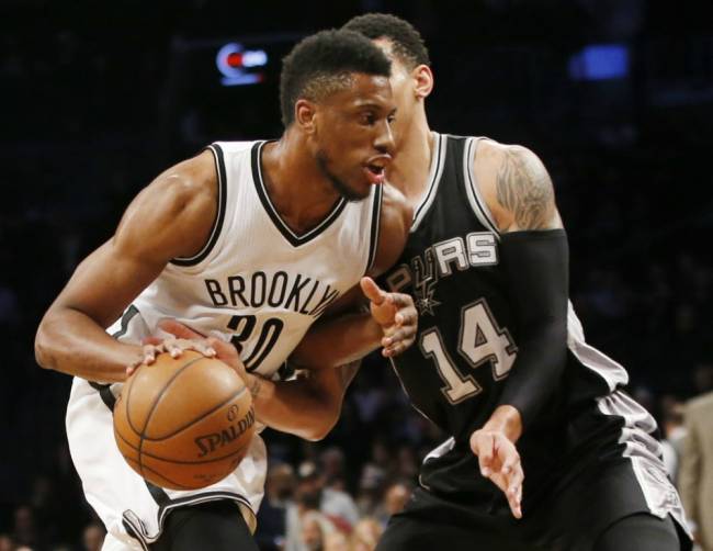 Spurs&#39 Danny Green right gets his hand on the ball as Nets&#39 Thaddeus Young drives to the basket in the first half Monday night at Barclays Center