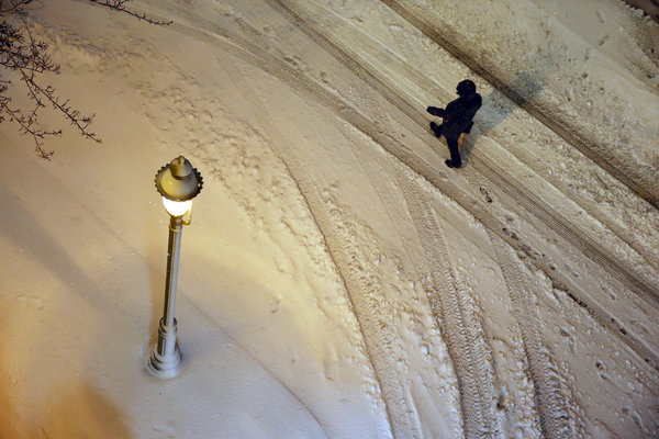 A man walks in car tracks during a snowstorm early Saturday Jan. 23 2016 in Atlantic City. Most of the state was facing a blizzard warning from Friday evening until Sunday that called for up to 24 inches of snow with the deepest accumulations in the