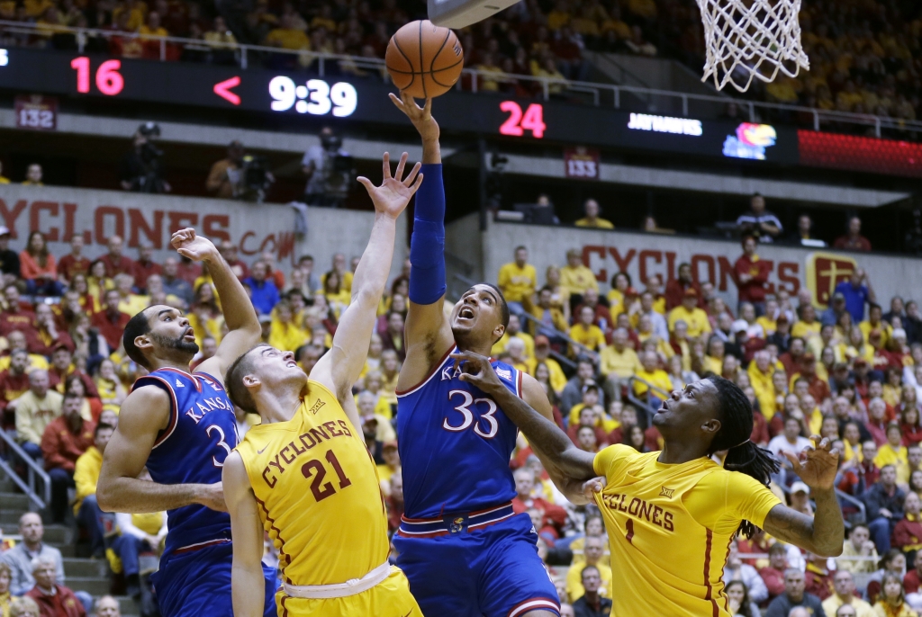 Kansas forward Landen Lucas fights for a rebound with Iowa State's Matt Thomas and Jameel McKay right during the first half of an NCAA college basketball game Monday Jan. 25 2016 in Ames Iowa. Kansas forward Perry Ellis left looks