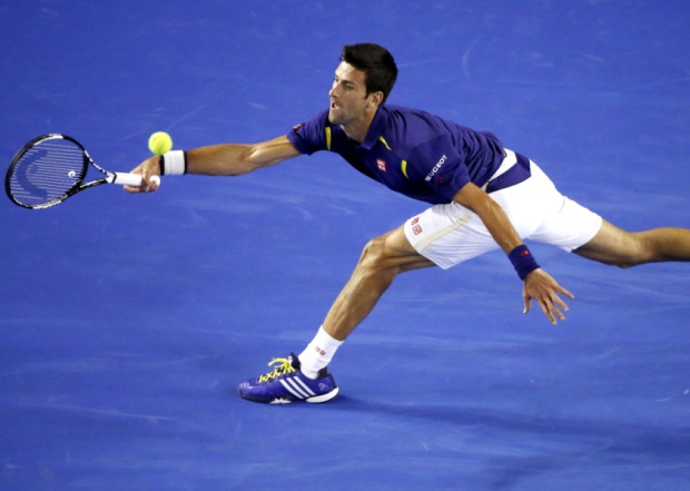 Novak Djokovic of Serbia hits a forehand return to Quentin Halys of France