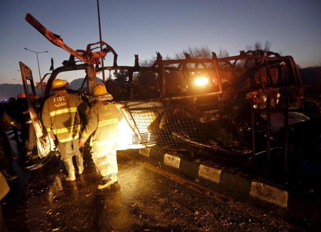 Firefighters inspect the wreckage of a bus hit by a suicide bomb attack in Kabul Afghanistan on Wednesday