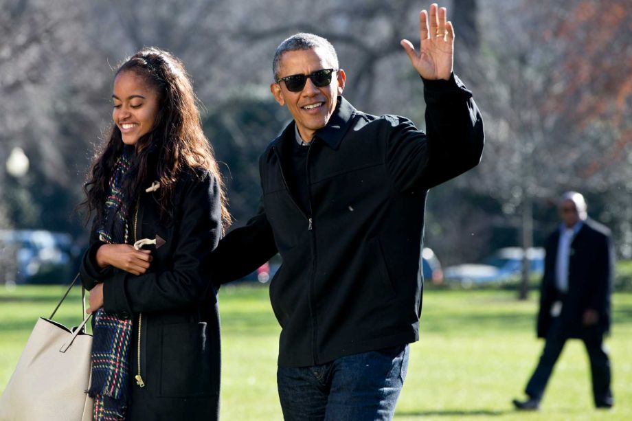 President Barack Obama waves as he walks with his daughter Malia Obama across the South Lawn on return to the White House in Washington Sunday Jan. 3 2016 after their family vacation in Hawaii