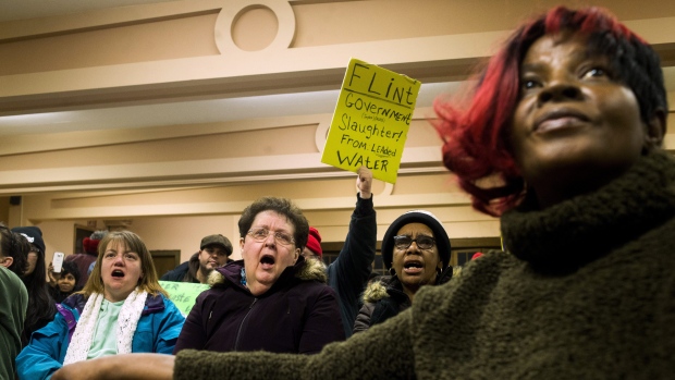 Flint residents Keri Webber left and Janice Barryman centre shouts out in support as more than 150 gather to protest against Gov. Rick Snyder asking for his resignation and arrest in relation to Flint's water crisis Thursday