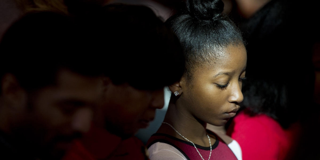 Karissa Ferrell-Hinkle 13 observes a moment of prayer during the Rev. Martin Luther King Jr. holiday commemorative service at Ebenezer Baptist Church where King preached