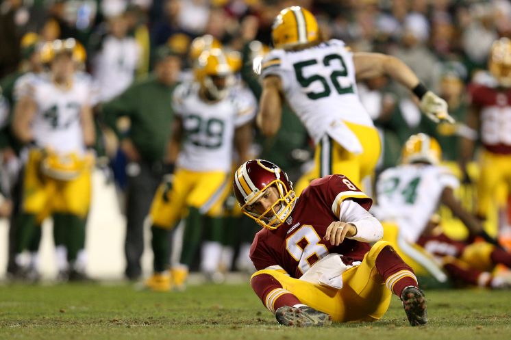 Washington quarterback Kirk Cousins sits after taking a hit against the Packers in the second quarter. Green Bay sacked Cousins six times and forced him to fumble once