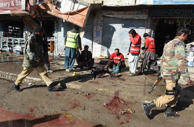 Pakistani security officials examine the site of a bomb blast near a polio vaccination center in Quetta