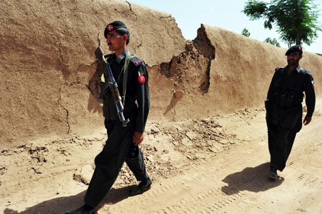 Pakistani security personnel patrol a street on the outskirts of Peshawar