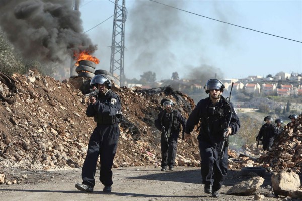 Israeli border guards walk down a road during clashes with Palestinian protesters following a demonstration on Dec. 25 2015 in the village of Kfar Qaddum near Nablus in the West Bank. JAAFAR ASHTIYEH AFP Getty Images