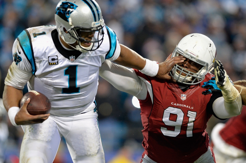 Cam Newton of the Carolina Panthers stiff arms Ed Stinson of the Arizona Cardinals in the second half during the NFC Championship Game at Bank of America Stadium on Sunday in Charlotte North Carolina