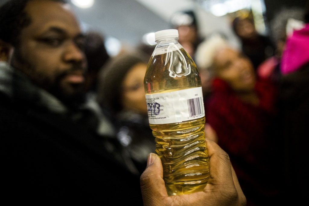 Pastor David Bullock holds up a bottle of Flint water on Jan