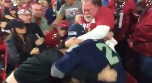 Spectators throw down with a diehard Seattle Seahawks fan at the Green Bay Packers Arizona Cardinals game on Saturday