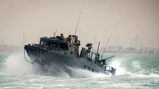 U.S. Navy Riverine Command Boat 805 is shown transiting through rough seas during patrol operations in the Persian Gulf