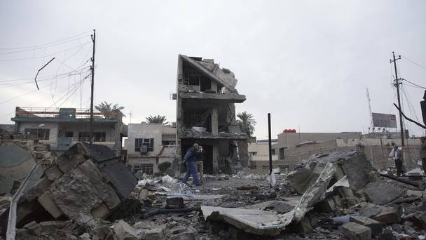 People gather at the scene in the aftermath of a car bomb explosion in commercial area of New Baghdad