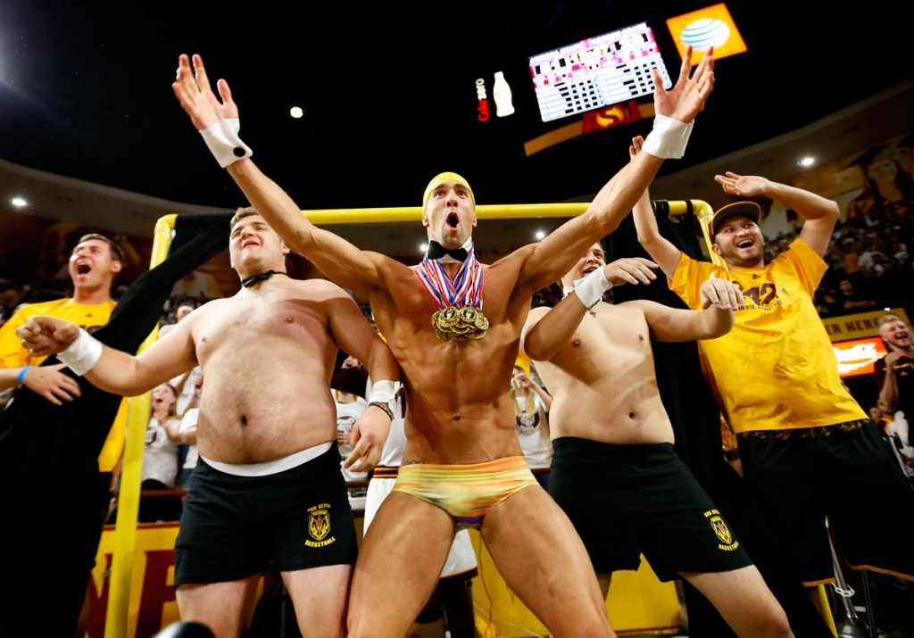 Olympic swimmer Michael Phelps center performs behind the'Curtain of Distraction during an Oregon State free throw against Arizona State in the second half of an NCAA college basketball game Thursday Jan. 28 2016 in Tempe Arizona