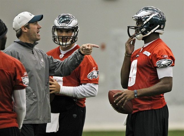 Philadelphia Eagles quarterbacks coach Doug Pederson left points to quarterback Vince Young as quarterback Mike Kafka looks on at center during an indoor practice at their NFL football training facility in Ph