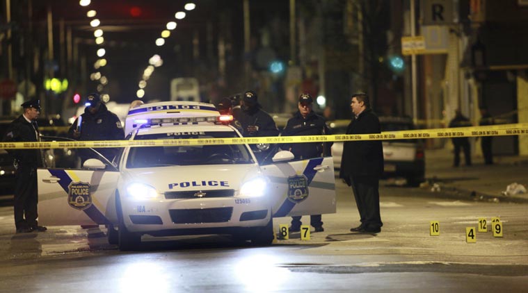 Officials investigate the scene of a shooting Friday Jan. 8 2016 in Philadelphia. A Philadelphia police officer was shot multiple times by a man who ambushed him as he sat in his marked police cruiser authorities said