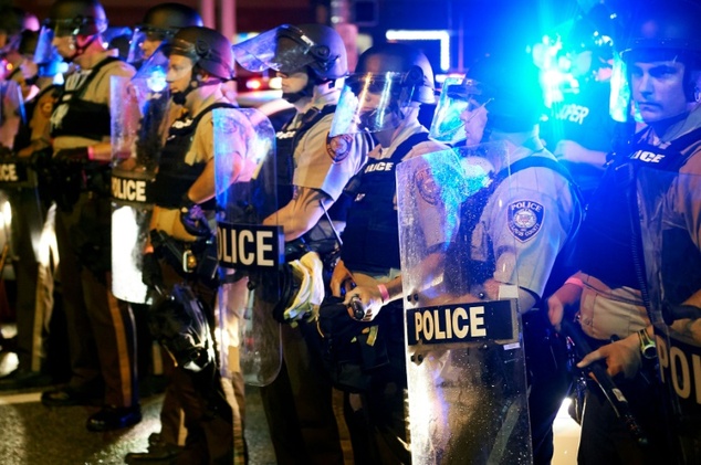 Police stand guard as protesters march in Ferguson Missouri