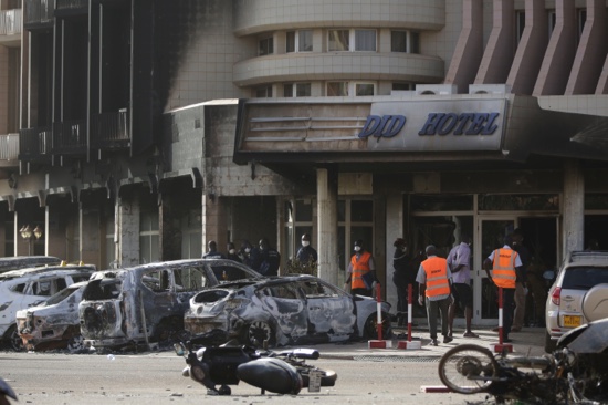 Rescue workers inspect damaged cars at the entrance of the Splendid Hotel in Ouagadougou Burkina Faso