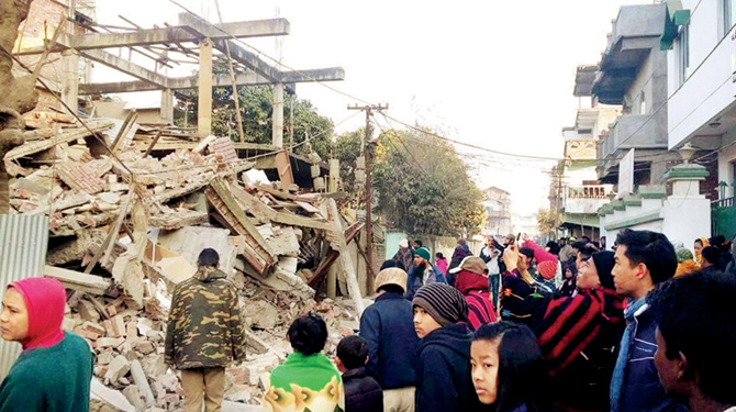 Residents gather near a collapsed building in Imphal. PIC  PTI