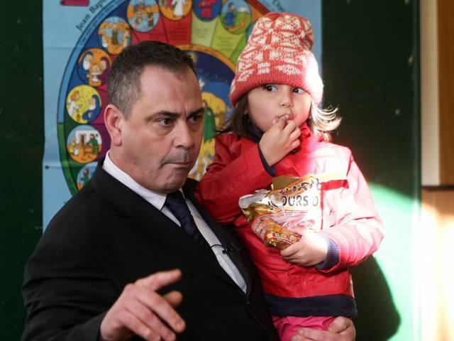 Robert Lawrie carries four-year-old Afghan refugee Bahar Ahmadi on Thursday in Boulogne-sur-Mer France