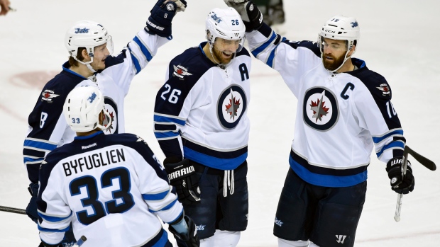 Blake Wheeler centre gets appreciative pats on the head from his Winnipeg teammates after his first-period goal against the Minnesota Wild. It was Wheeler's second game-winner in as many nights as the Jets won 1-0