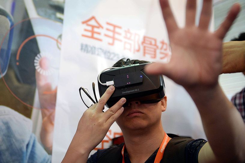 A visitor tries on virtual reality glasses from Oculus Rift Development Kit 2 during the first Consumer Electronics Sh