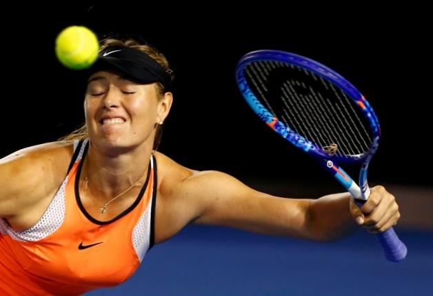 Russia's Maria Sharapova reacts as she hits a shot using her left hand during her third round match against Lauren Davis of the U.S. at the Australian Open tennis tournament at Melbourne Park Australia