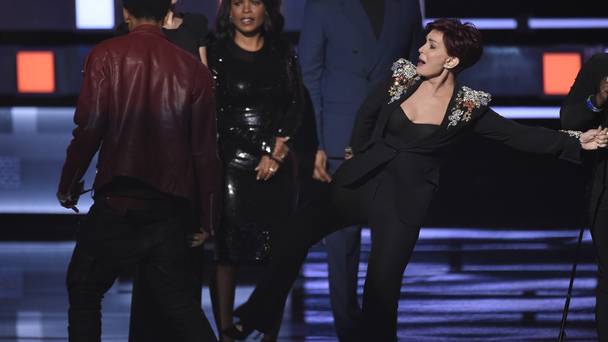 Sharon Osborne aims a kick at the man who invaded the stage at the People's Choice Awards