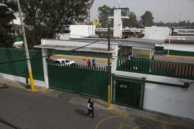 A woman walks past the compound of the Agujas immigration detention center where U.S. fugitive Ethan Couth is being detained in Mexico City Thursday Dec