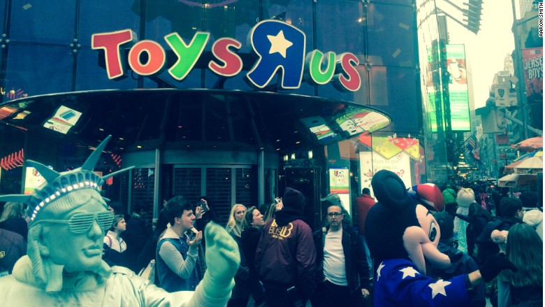 Shoppers gather outside Toys'R Us on its very last day in Times Square but many of the shelves inside were bare
