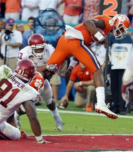 Clemson quarterback Deshaun Watson scores a touchdown as Oklahoma safety Ahmad Thomas holds on to his leg during the first half of the Orange Bowl NCAA college football semifinal playoff game Thursday Dec. 31 2015 in Miami Gardens Fla. (AP