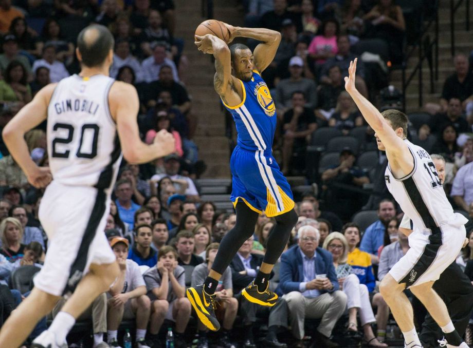 Golden State Warriors guard Andre Iguodala center looks to pass around San Antonio Spurs forward Aron Baynes right of Australia as Spurs guard Manu Ginobili of Argentina looks on during the second half of an NBA basketball game Sunday