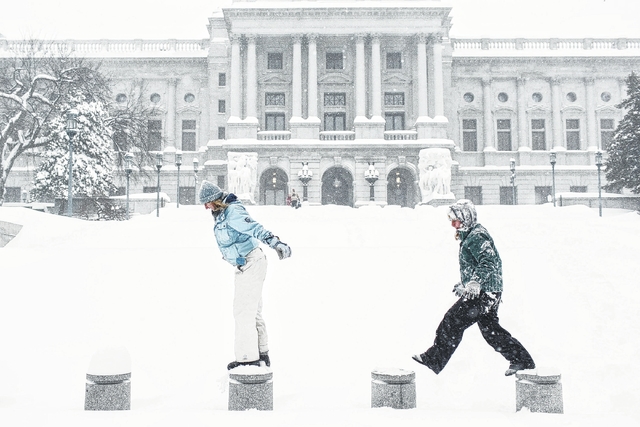 Stephanie Williams and her sister Joely Wilkinson play in the snow in front of the capitol on Saturday