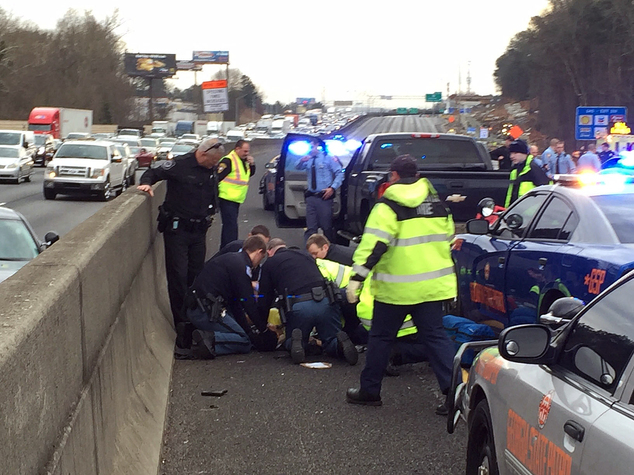 First responders are shown working on a suspect that was shot following a chase on Interstate 75 in Cobb County. A state trooper and a suspect were shot Wedn