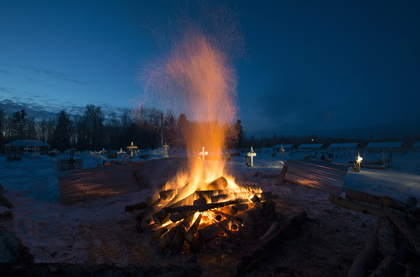 A fire burns as it thaws the frozen ground in order to dig a grave for one of the shooting victims at the cemetery in La Loche Saskatchewan Monday Jan. 25 2016. A 17-year-old was charged with first-degree murder and attempted murder in a mass shooting