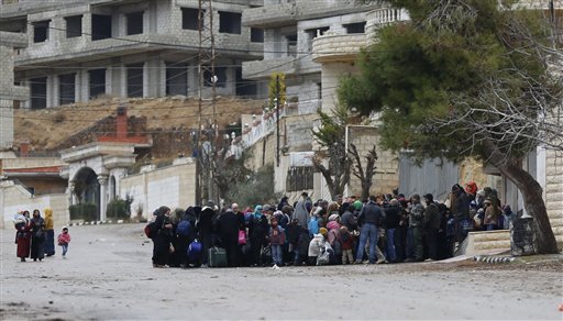 Syrians wait for an aid convoy in the besieged town of Madaya in the countryside of Damascus