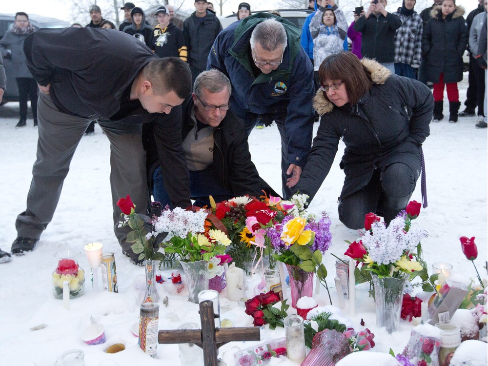 From left La Loche Mayor Kevin Janvier lSaskatchewan Premier Brad Wall federal Public Safety Minister Ralph Goodale and MLA Georgina Jolibois lay flowers at a makeshift memorial at La Loche Sask. on Sunday. A shooting Friday left four people dead