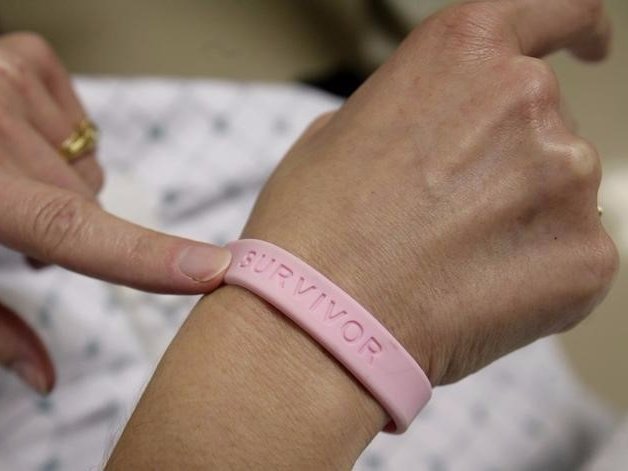 After three operations and four rounds of chemotherapy at Georgetown University Hospital cancer patient Deborah Charles shows off her breast cancer survivor bracelet during a hospital appointment in Washingt