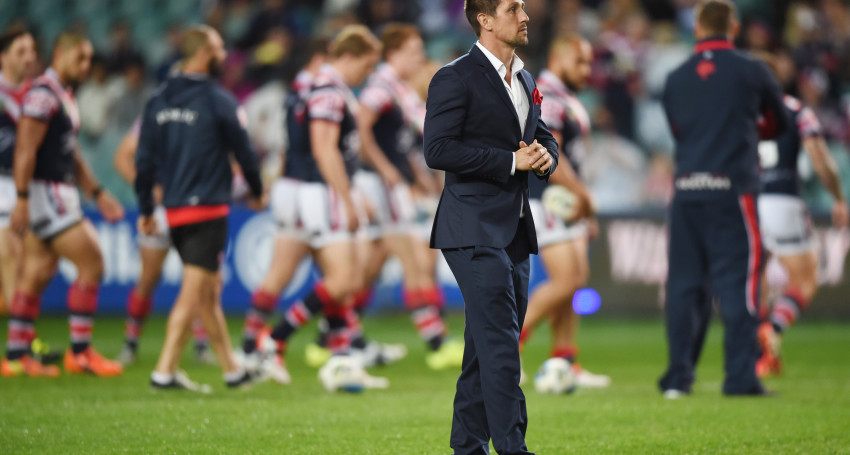 An injured Mitchell Pearce watches his team warm up before last