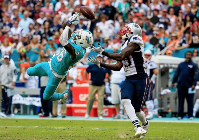 Tony Lippett breaks up a pass intended for Brandon La Fell Sunday in South Florida