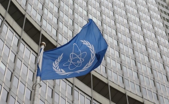 The flag of the International Atomic Energy Agency flies in front of its headquarters in Vienna Austria