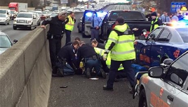 Caption First responders are shown working on a suspect that was shot following a chase on Interstate 75 in Cobb County. A state trooper and a suspect were shot Wednesday Jan. 27 2016 in a police