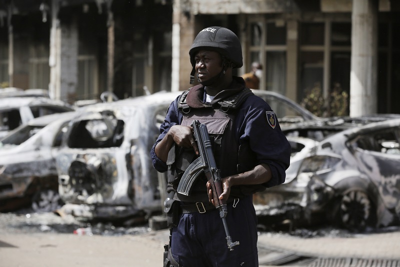 A police officer stands guard outside the Splendid Hotel in Ouagadougou Burkina Faso Sunday Jan. 17 2016. The overnight seizure of a luxury hotel in Burkina Faso's capital by al Qaida-linked extremists ended Saturday when Burkina Faso and French